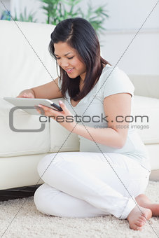 Woman holding a tactile tablet in front of a sofa