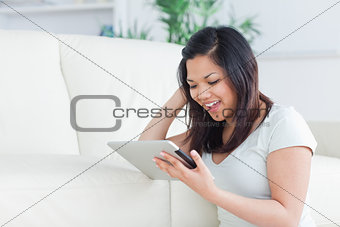 Woman playing with a tactile tablet while sitting on the floor