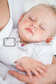Cute baby closing her eyes while being held