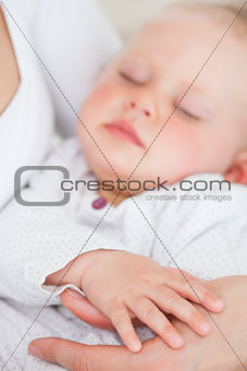 Peaceful baby being held by her mother