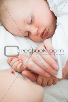 Peaceful little baby sleeping with her mother