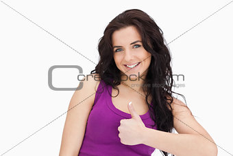 Smiling brunette the thumb-up