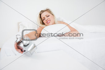 Upset woman looking at her alarm clock
