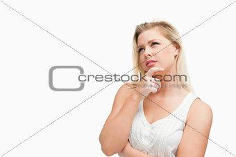 Blonde woman placing her fingers on her chin