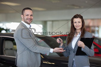 Woman giving car keys to a man