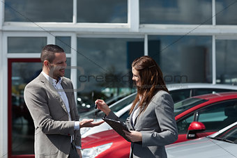 Businesswoman giving car keys to a client