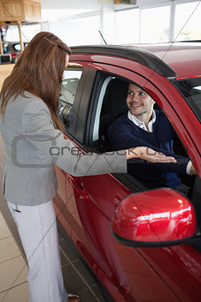 Businesswoman presenting the car to a client