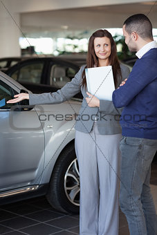 Woman showing a car to a client