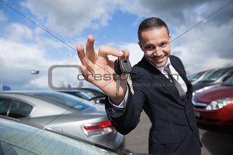 Happy dealer holding car keys