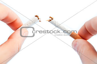 Fingers breaking a cigarette