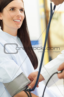 Smiling patient looking at a doctor while he his taking her bloo