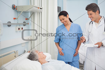 Doctor and nurse smiling to a patient