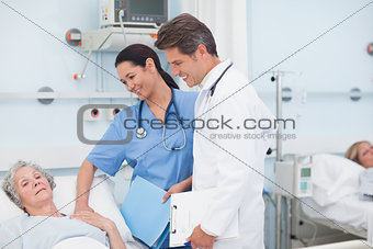 Nurse and doctor next to a patient