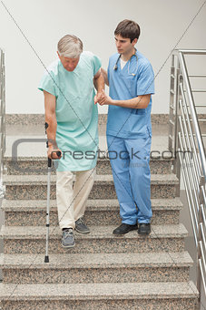 Male nurse assisting a patient on stairs