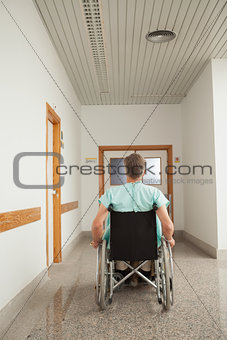 Male patient sitting in a wheelchair in the corridor