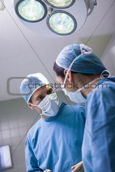 Serious doctor looking at a nurse