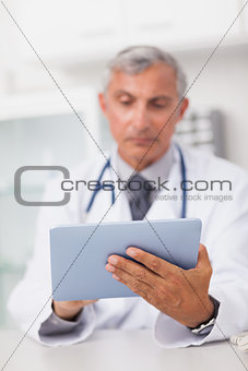 Doctor holding a tablet computer while using it