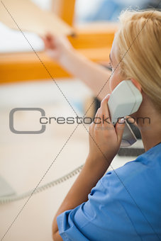 Nurse holding a phone and giving a folder
