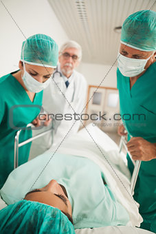 Patient lying on a medical bed next to doctors