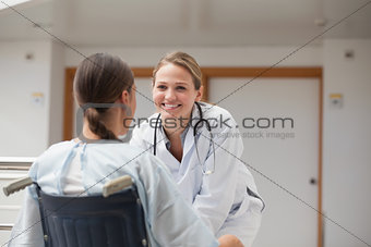 Smiling doctor in front of a patient on a wheelchair