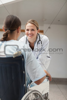 Doctor looking at a female patient on a wheelchair