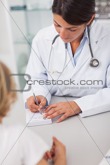 Doctor writing on a prescription note