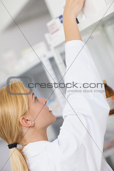 Blonde pharmacist taking a drug box