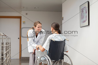 Patient sitting on a wheelchair in front of a doctor
