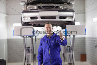 Smiling mechanic standing with thumb up