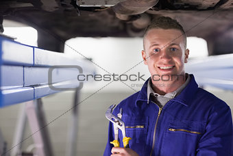 Smiling mechanic holding an adjustable pliers