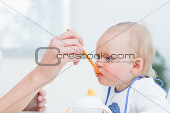 Baby with a plastic spoon on his mouth