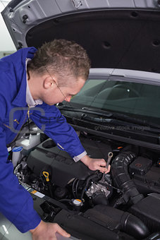 Mechanic repairing an engine with a spanner