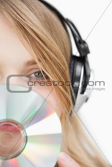 Close up of a blonde woman with a cd in front of her face