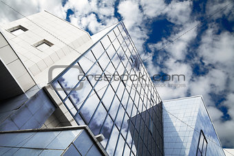 windows of skyscraper with reflections on a background cloudy sky