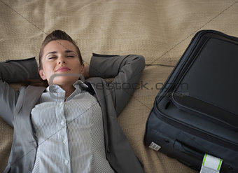 Tired business woman relaxing in hotel room after trip