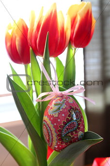 Easter egg decoration hanging from tulips