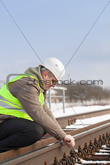 Railroad worker with adjustable wrench fix the nut