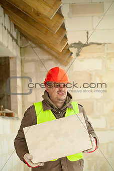 Builder with concrete block near new building