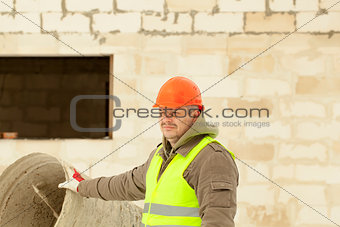 Builder at the new building near the concrete mixer