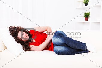 Girl on the sofa with stomach ache