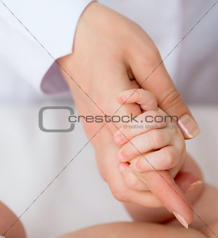 baby's hand with mother's finger