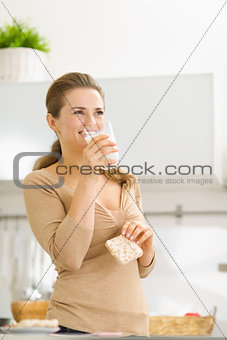 Young woman eating crisp bread with milk