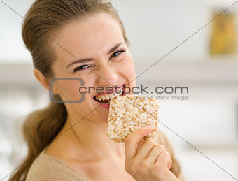 Happy young woman eating crisp bread