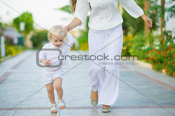 Mother and baby running outdoors