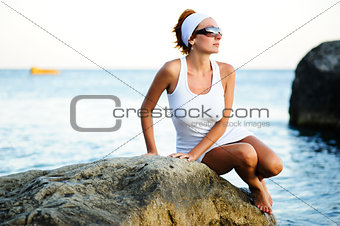 woman sitting on a stone in the sea