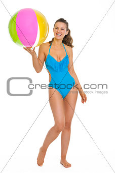 Full length portrait of smiling young woman in swimsuit with bea