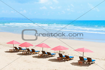  Tropical empty sandy beach with umbrellas