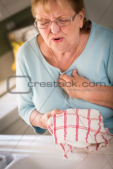 Senior Adult Woman At Sink With Chest Pains