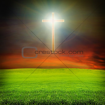 shining cross over dark sky and field