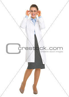 Full length portrait of smiling oculist doctor woman in eyeglass